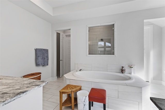 bathroom featuring a bath and baseboards