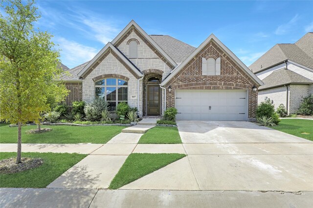 french country style house featuring a garage and a front yard