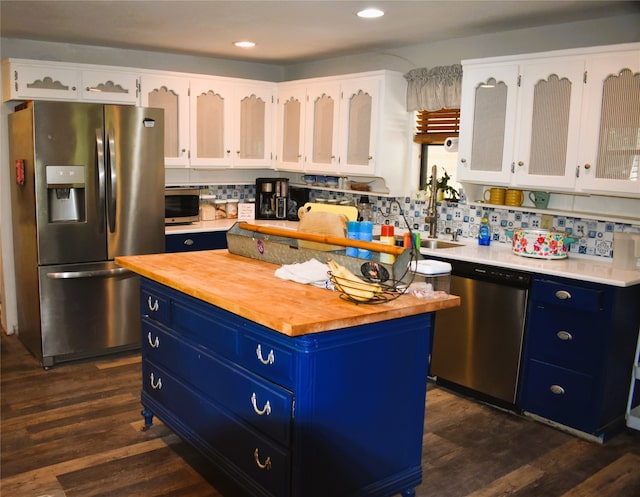 kitchen featuring appliances with stainless steel finishes, blue cabinets, white cabinets, and a center island