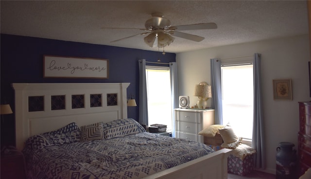 bedroom featuring ceiling fan, a textured ceiling, and multiple windows