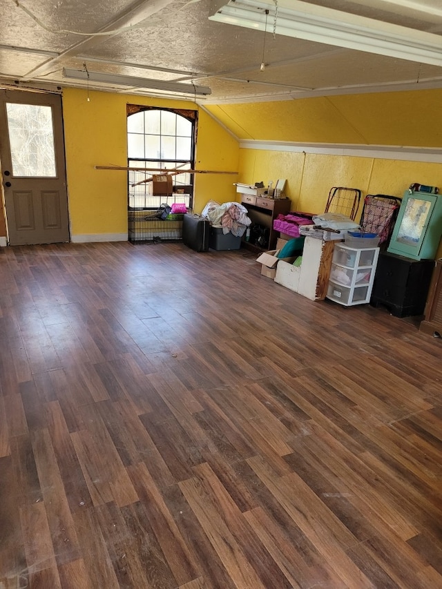 interior space featuring dark wood-type flooring, a wealth of natural light, lofted ceiling, and a textured ceiling