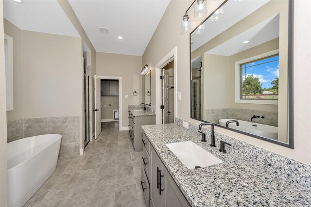 bathroom featuring tile patterned flooring, vanity, and a bathing tub