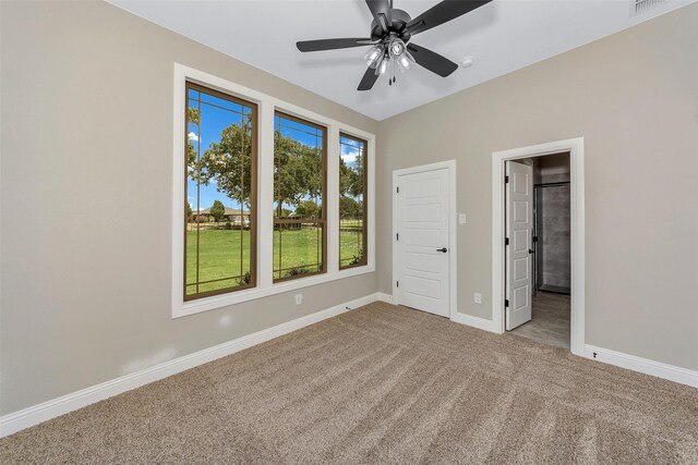 unfurnished bedroom with ceiling fan and light colored carpet