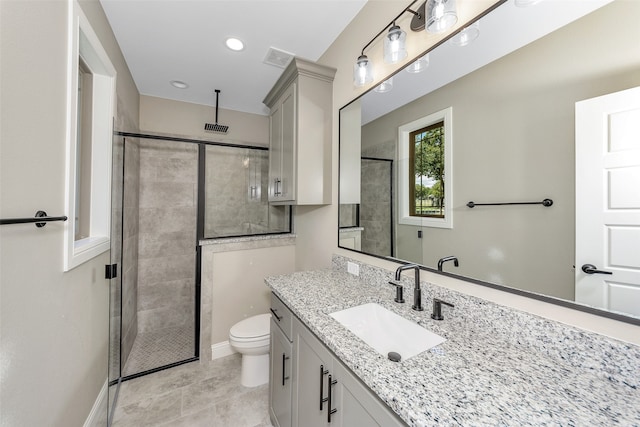 bathroom featuring tile patterned flooring, vanity, toilet, and a shower with shower door