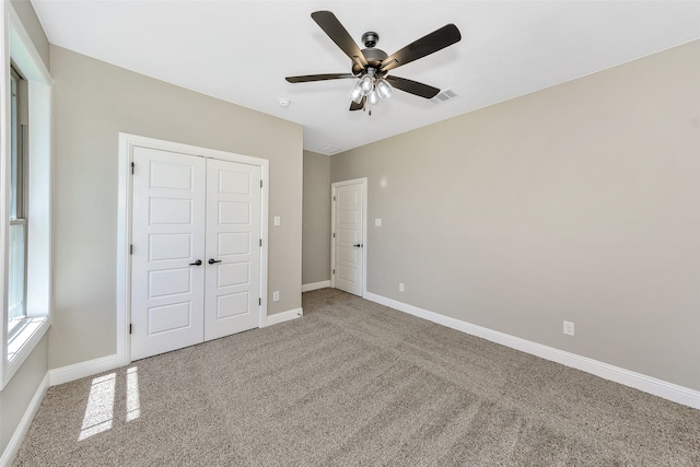 unfurnished bedroom with a closet, ceiling fan, and carpet floors