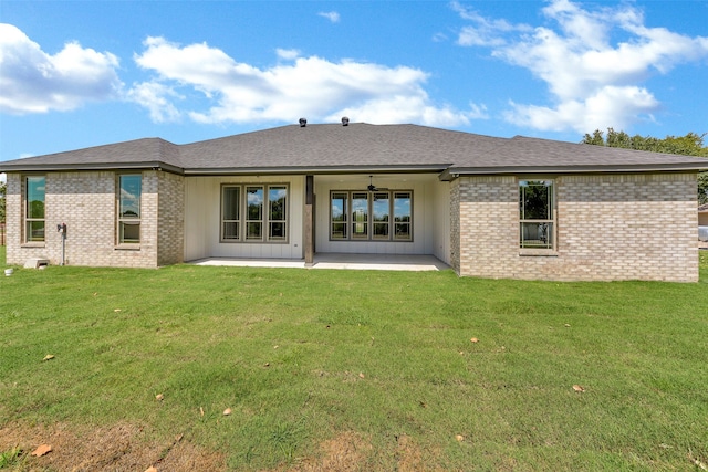 back of property with a lawn and a patio