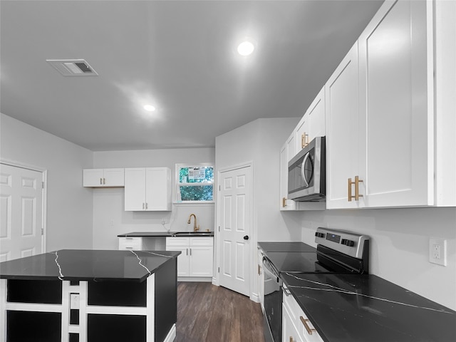 kitchen with a kitchen island, dark hardwood / wood-style flooring, appliances with stainless steel finishes, sink, and white cabinetry