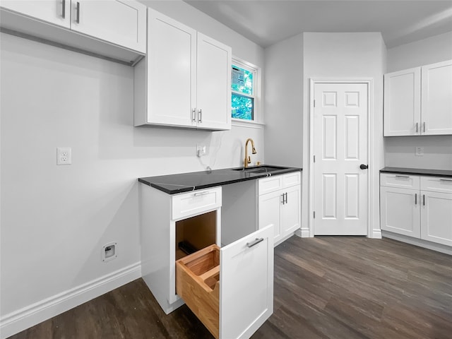 kitchen with dark wood-type flooring, white cabinetry, and sink