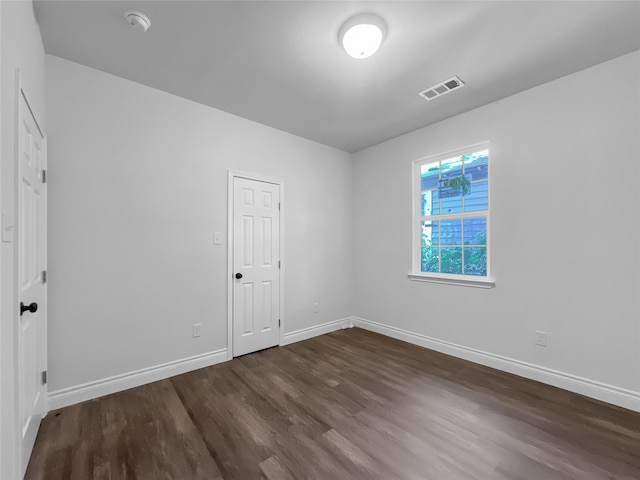 spare room featuring dark wood-type flooring