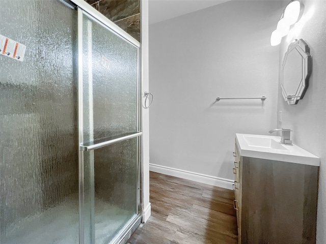 bathroom with vanity, an enclosed shower, and wood-type flooring