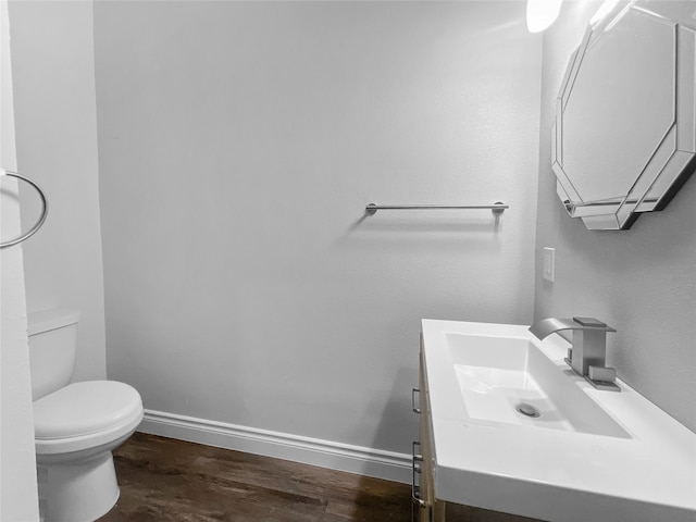 bathroom featuring vanity, toilet, and hardwood / wood-style floors