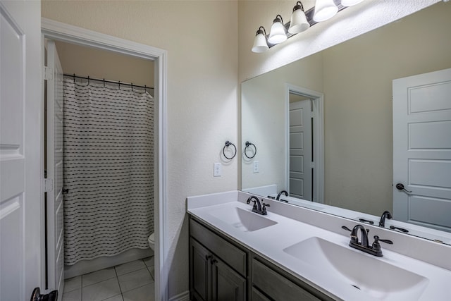 bathroom with tile patterned flooring, vanity, toilet, and curtained shower