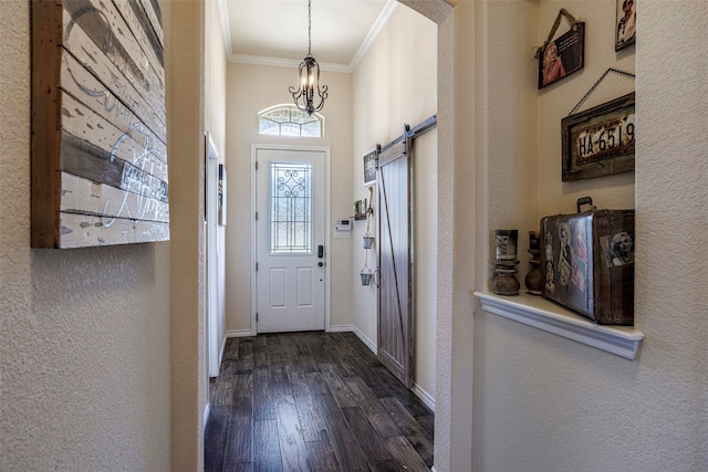 foyer entrance featuring crown molding, a barn door, a notable chandelier, and dark hardwood / wood-style flooring