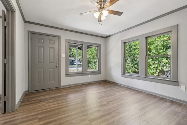 unfurnished room with crown molding, dark wood-type flooring, and ceiling fan