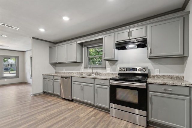 kitchen with gray cabinets, appliances with stainless steel finishes, crown molding, and sink