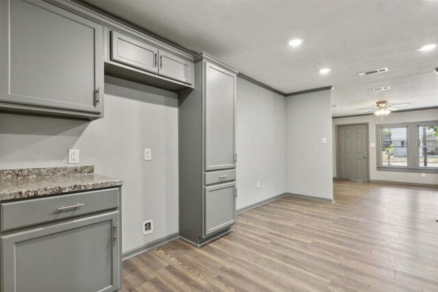 kitchen featuring light wood-type flooring, stone counters, ceiling fan, and gray cabinetry