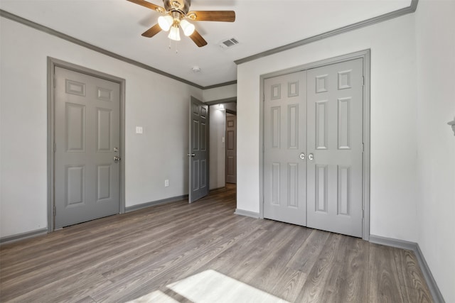 unfurnished bedroom with crown molding, ceiling fan, a closet, and light hardwood / wood-style floors