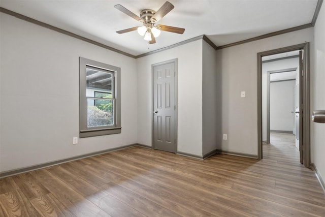 unfurnished bedroom featuring crown molding, baseboards, and wood finished floors