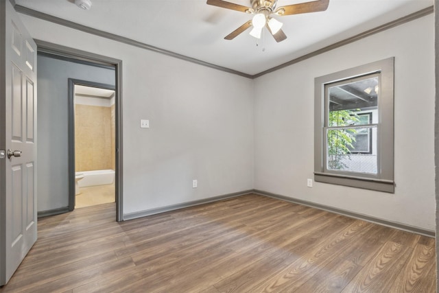 empty room featuring baseboards, ornamental molding, ceiling fan, and wood finished floors