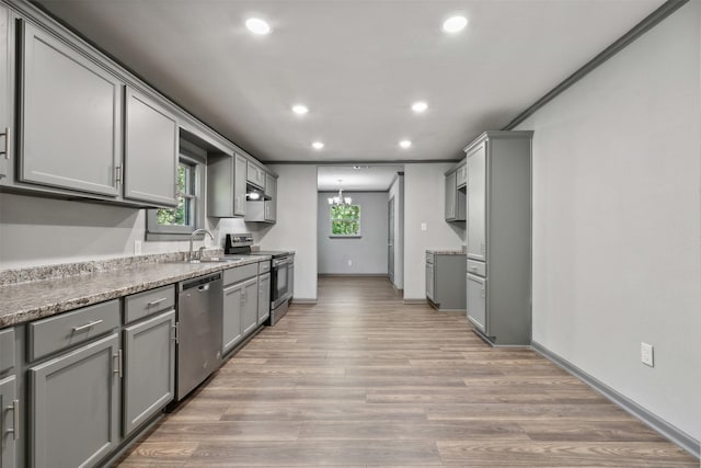 kitchen featuring light wood-type flooring, an inviting chandelier, appliances with stainless steel finishes, and gray cabinets