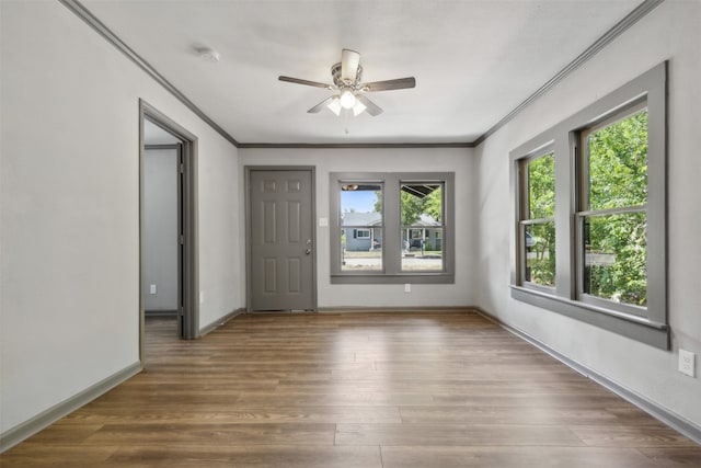 empty room with hardwood / wood-style floors, ceiling fan, and crown molding