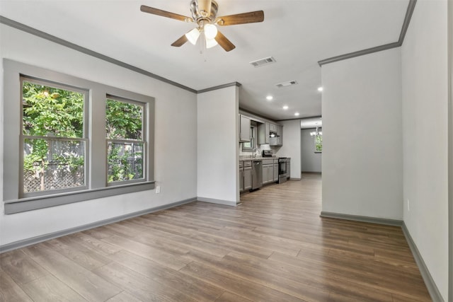 unfurnished living room with crown molding, visible vents, and wood finished floors