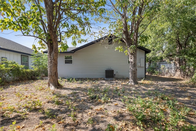 view of side of home featuring central AC and fence