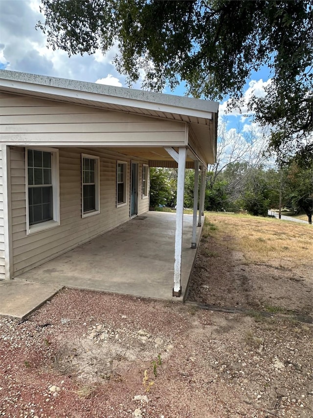 view of patio with a carport and dirt driveway