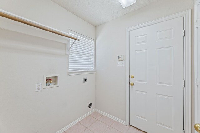 washroom featuring a textured ceiling, electric dryer hookup, washer hookup, and light tile patterned flooring