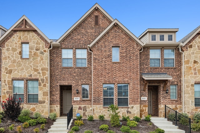 townhome / multi-family property with stone siding and brick siding