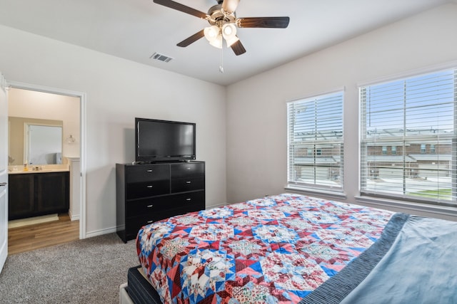 carpeted bedroom with ceiling fan and connected bathroom