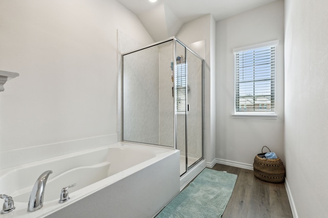 bathroom with hardwood / wood-style floors, independent shower and bath, and vaulted ceiling