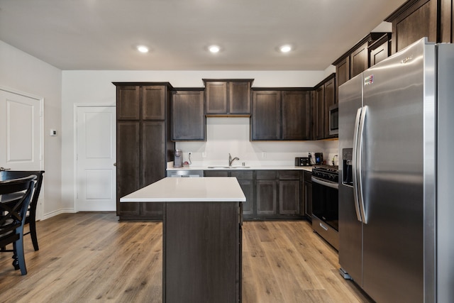 kitchen with light hardwood / wood-style flooring, stainless steel appliances, a kitchen island, sink, and dark brown cabinetry