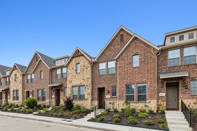 townhome / multi-family property with stone siding and brick siding