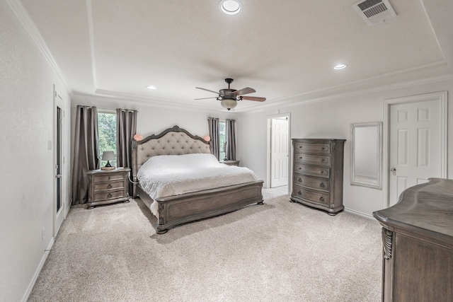 carpeted bedroom with ornamental molding, a tray ceiling, and ceiling fan