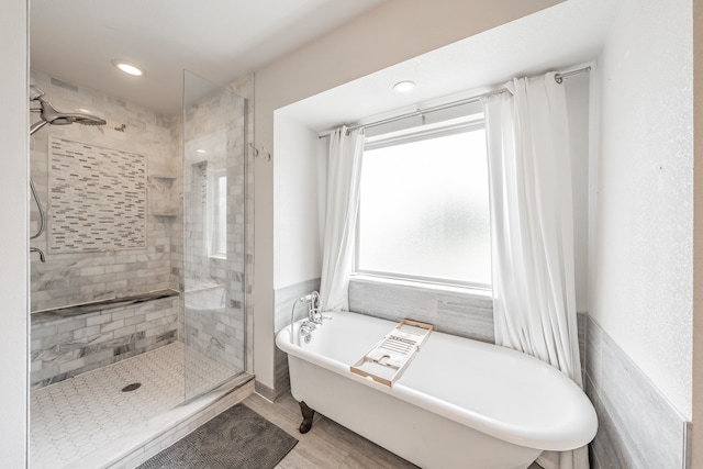 full bathroom featuring a stall shower and a soaking tub