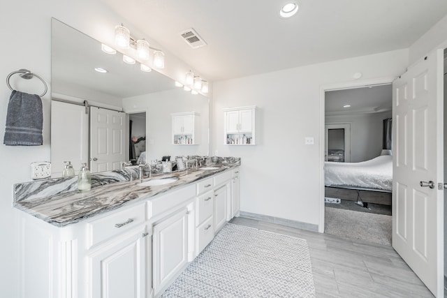 ensuite bathroom with a sink, double vanity, ensuite bath, and visible vents