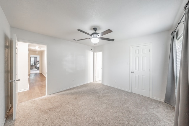 unfurnished bedroom featuring light colored carpet and ceiling fan