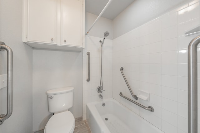 bathroom featuring toilet and tiled shower / bath