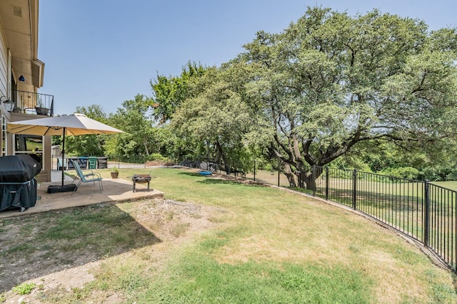 view of yard with a balcony, a fenced backyard, a fire pit, and a patio