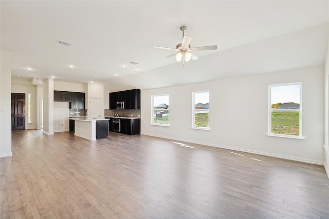 unfurnished living room featuring lofted ceiling, hardwood / wood-style floors, and ceiling fan