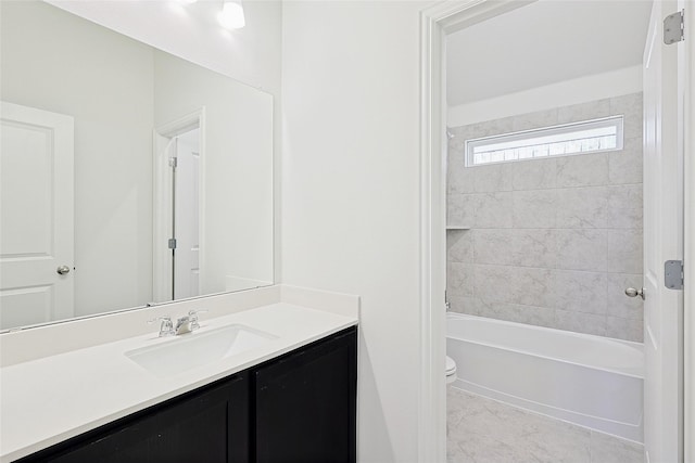 full bathroom featuring tiled shower / bath, vanity, toilet, and tile patterned flooring