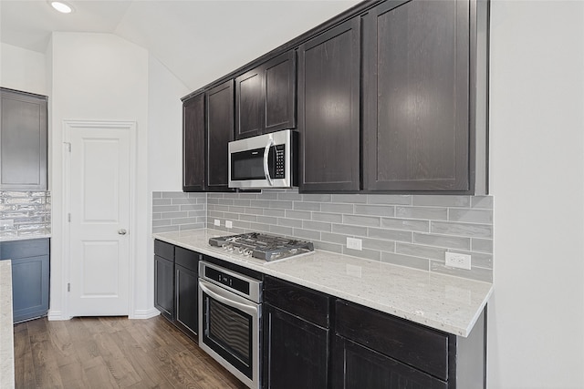 kitchen featuring ceiling fan, lofted ceiling, decorative light fixtures, a kitchen island with sink, and appliances with stainless steel finishes