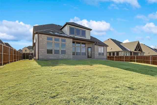 rear view of property featuring a yard and cooling unit