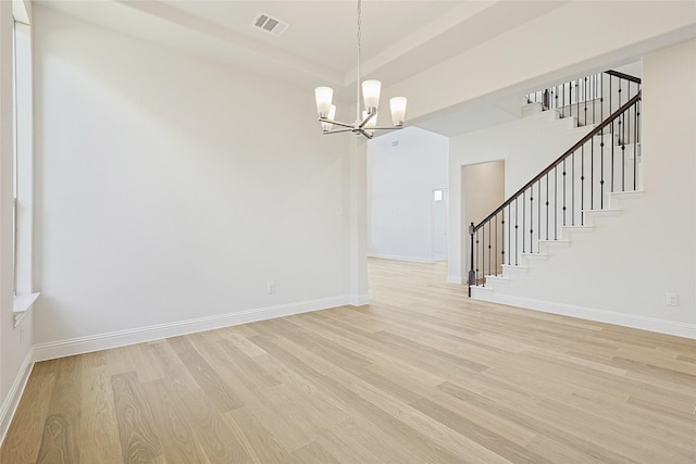 unfurnished room featuring light hardwood / wood-style floors and a chandelier