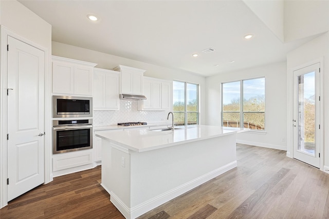 kitchen featuring an island with sink, appliances with stainless steel finishes, white cabinets, and sink