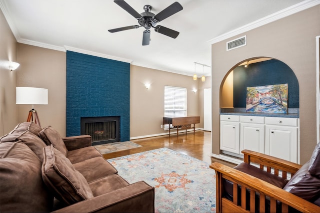 living room featuring crown molding, dark wood-type flooring, a fireplace, and ceiling fan