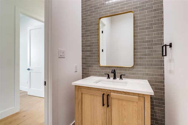 bathroom featuring hardwood / wood-style floors, backsplash, tile walls, and vanity