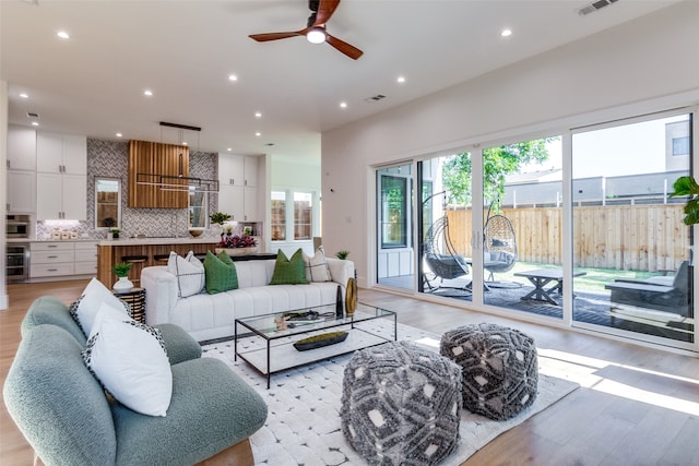 living room featuring ceiling fan and light hardwood / wood-style floors