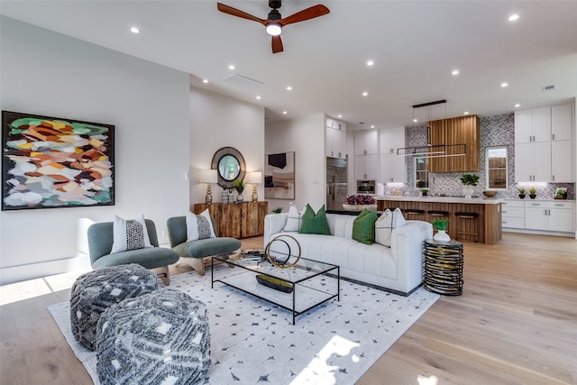 living room featuring ceiling fan and light hardwood / wood-style floors